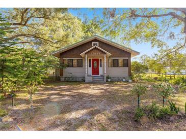 Charming one-story house with red front door and mature trees at 10135 Se 108Th Terrace Rd, Ocala, FL 34472