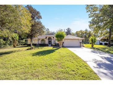 Single-story house with a well-maintained lawn and a two-car garage at 5336 Sw 109Th Place Rd, Ocala, FL 34476