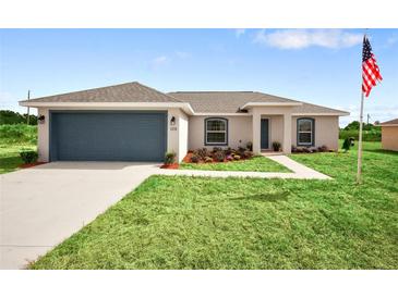 Newly built home with a two-car garage and well-manicured lawn at 28 Juniper Pass Dr, Ocala, FL 34480