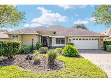 Single-story home with a landscaped yard, paver driveway and two-car garage at 8470 Sw 82Nd Cir, Ocala, FL 34481