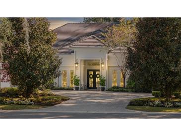 Elegant home with a white exterior, paver driveway, and lush landscaping at 8725 Nw 31St Lane Rd, Ocala, FL 34482