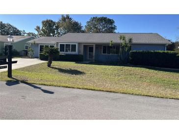 Ranch-style home with blue siding, grey roof and landscaped lawn at 10962 Sw 81St Ave, Ocala, FL 34481