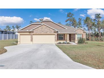 One-story home with three-car garage, stone accents, and landscaped yard at 4313 Sw 106Th Pl, Ocala, FL 34476