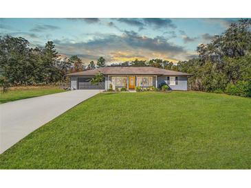 Ranch style home with gray exterior, attached garage, and well-manicured lawn at 15330 Sw 59Th Ct, Ocala, FL 34473