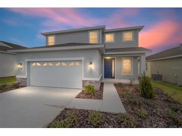 Two-story house with gray siding, stone accents, and a two-car garage at 5886 Sw 78Th Avenue Rd, Ocala, FL 34474
