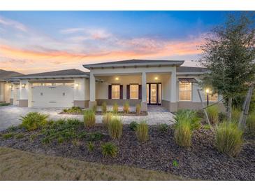 Single-story home with covered porch, two-car garage, and landscaped yard at 9725 Sw 108Th Terrace Rd, Ocala, FL 34481