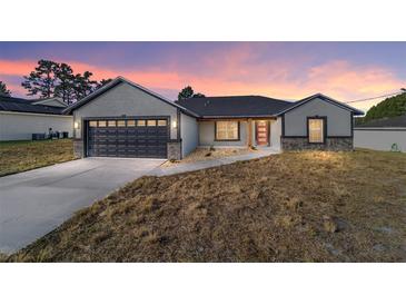 New construction home with gray siding, black garage door, and a red front door at 54 Dogwood Drive Loop, Ocala, FL 34472