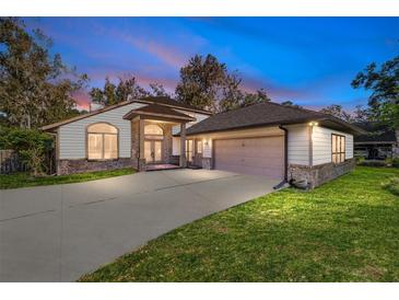 Two-story house with a two-car garage, manicured lawn, and brick accents at dusk at 1825 Se 36Th Pl, Ocala, FL 34471