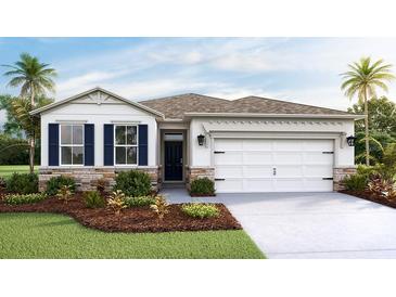 Single-story home with two-car garage, stone accents, and landscaping at 8552 Pinecrest Trl, Wildwood, FL 34785