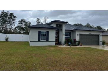 One-story home with gray siding, black shutters, and a two-car garage at 15720 Sw 19Th Ter, Ocala, FL 34473