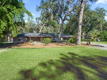 Ranch style home with mature landscaping and a large grassy yard at 6657 W Highway 326, Ocala, FL 34482