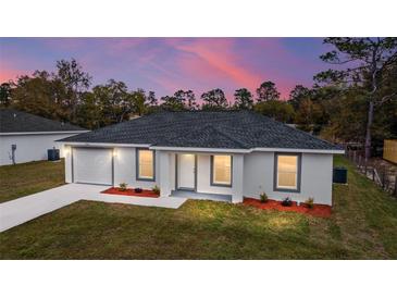 Charming single-story home with a welcoming front yard at sunset at 13559 Sw 115 Pl, Dunnellon, FL 34432