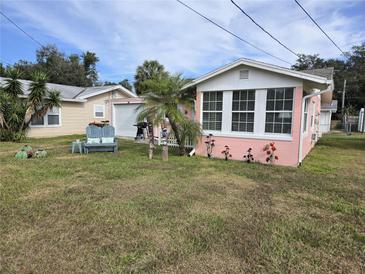 Pink Florida home with a white picket fence, spacious yard, and mature trees at 12451 Se 135Th Ct, Ocklawaha, FL 32179