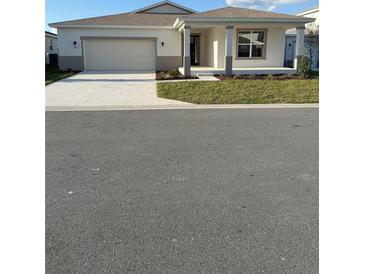 New construction home with a two-car garage and covered porch at 7719 Sw 59Th Ln, Ocala, FL 34474