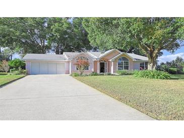 Cute ranch home with attached two-car garage and well-manicured lawn at 8225 Sw 108Th Loop, Ocala, FL 34481