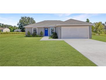 Newly built home with a gray exterior, blue door, and attached garage at 115 Guava Place Dr, Ocklawaha, FL 32179