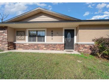Home's front entrance with stone accents and landscaping at 6931 Se 54Th St, Ocala, FL 34472