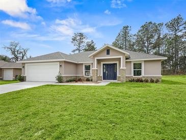 Newly constructed home with a white garage door and a nicely landscaped lawn at 16691 Sw 30Th Terrace Rd, Ocala, FL 34473