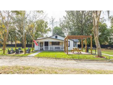 Charming white cottage with a spacious yard, pergola, and patio at 2751 Ne 46Th St, Ocala, FL 34479