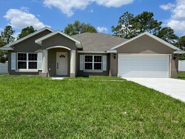Newly constructed home with a two-car garage and well-manicured lawn at 5230 Nw 56Th Ter, Ocala, FL 34482