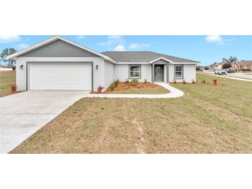 Newly constructed home with gray exterior, landscaping, and a two-car garage at 2809 Ne 43Rd Rd, Ocala, FL 34470