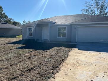 Newly constructed home with a two-car garage and well-maintained lawn at 178 Pine Crse, Ocala, FL 34472