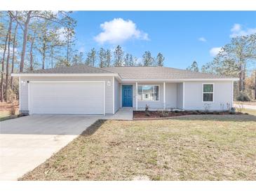 Newly constructed one-story home with gray siding, attached garage, and a blue front door at 24440 Nw Falcon Ave, Dunnellon, FL 34431