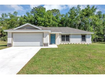Newly built home with a two-car garage and well-manicured lawn at 13460 Sw 107 St, Dunnellon, FL 34432