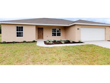 Single-story house with attached garage, landscaping, and neutral color scheme at 1697 Ne 161St St, Citra, FL 32113