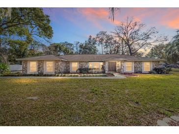 Single-story home with stone facade, and a large grassy yard at 2528 Se 15Th St, Ocala, FL 34471