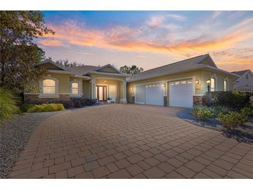 Evening view of a charming two-story house with a brick driveway and two-car garage at 9015 Sw 86Th Loop, Ocala, FL 34481