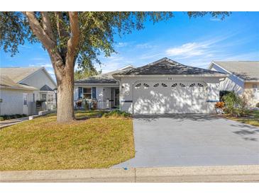 White one-story house with a two-car garage and landscaping at 9158 Sw 91St Ter, Ocala, FL 34481
