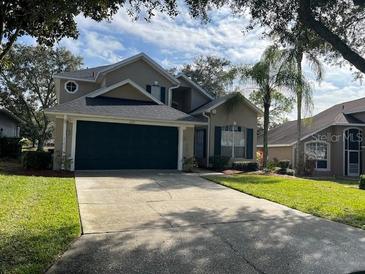 Two-story house with a green garage door and manicured lawn at 2213 Mallory Cir, Haines City, FL 33844