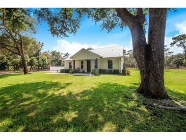 Charming farmhouse with metal roof, large yard, and covered porch at 12510 Lake Hatchineha Rd, Haines City, FL 33844