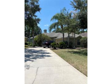 Single-Gathering home with driveway, landscaping, and palm trees at 102 Jardin Ln, Winter Haven, FL 33884
