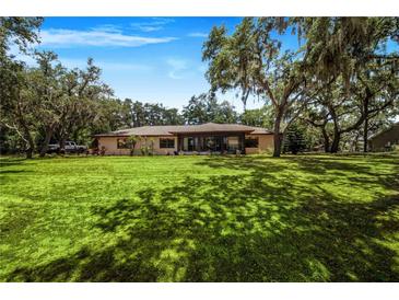 Single-story home with a large backyard and mature trees at 8881 Cypresswood Dr, Lake Wales, FL 33898