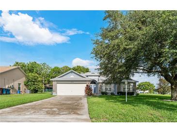 Charming single-story home with a two-car garage and mature landscaping at 4353 Dinner Lake Dr, Lake Wales, FL 33859