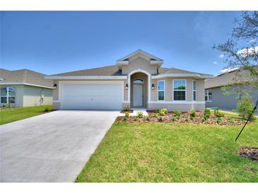 New construction home with a two car garage and landscaped yard at 1253 Tagliamento Ln, Haines City, FL 33844