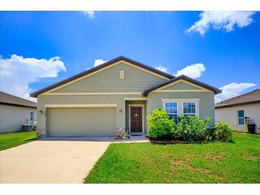 One-story house with green exterior, two-car garage, and landscaping at 4850 St James Ct, Winter Haven, FL 33881