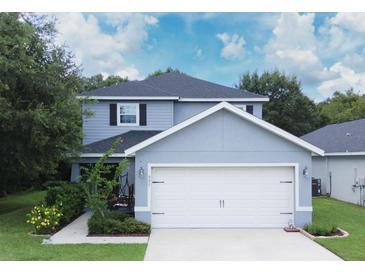 Two-story house with gray siding, white garage door, and landscaping at 997 Pearly Ridge Ln, Lakeland, FL 33809