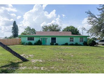 Mint green house with brown roof and green lawn at 15 Winterset Dr, Winter Haven, FL 33884