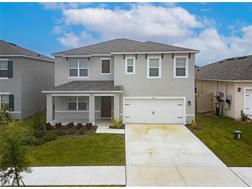 Two-story house with gray siding and two-car garage at 460 Boardwalk Ave, Haines City, FL 33844