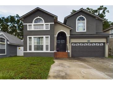 Two-story house with gray siding, a double garage, and a brick walkway at 5219 Mystic Point Ct, Orlando, FL 32812
