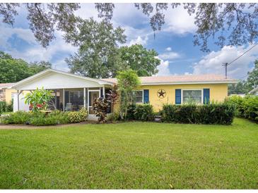 Charming yellow house with a well-manicured lawn and screened porch at 122 Bishop St, Auburndale, FL 33823