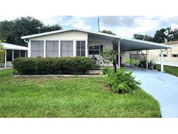 Mobile home with carport and landscaped yard at 191 Sweet Cir, Winter Haven, FL 33884