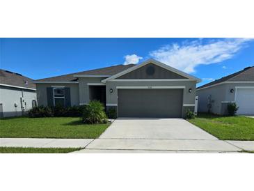 Single-story home with gray siding and two-car garage at 1036 Mattie Pointe Way, Auburndale, FL 33823