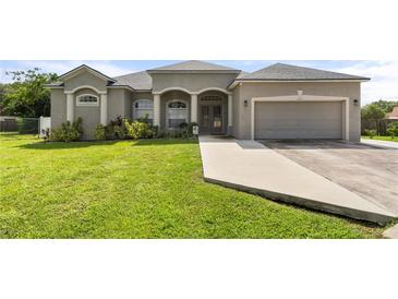 One-story home with a two-car garage and well-manicured lawn at 191 Lake Thomas Dr, Winter Haven, FL 33880