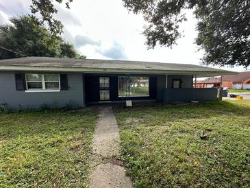 Ranch-style home with gray exterior and a well-maintained lawn at 100 Stevenson Rd, Winter Haven, FL 33884