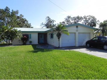 Single-story house with a two-car garage and a lawn at 2201 W Pilaklakaha Ave, Auburndale, FL 33823