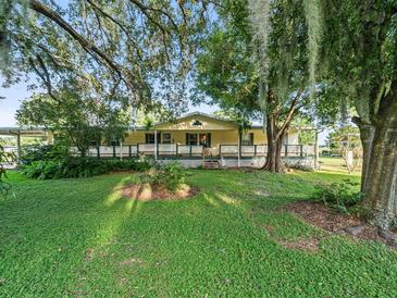 Ranch style home with large front porch and mature trees at 126 Bermuda Ct, Winter Haven, FL 33880